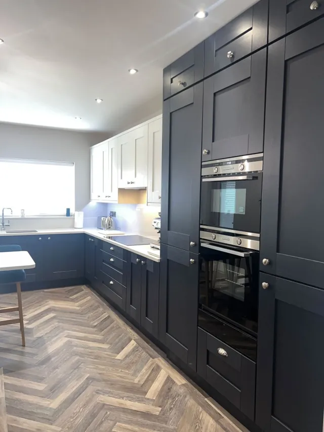Near-black Shaker cabinetry with tall oven housing and light worktops