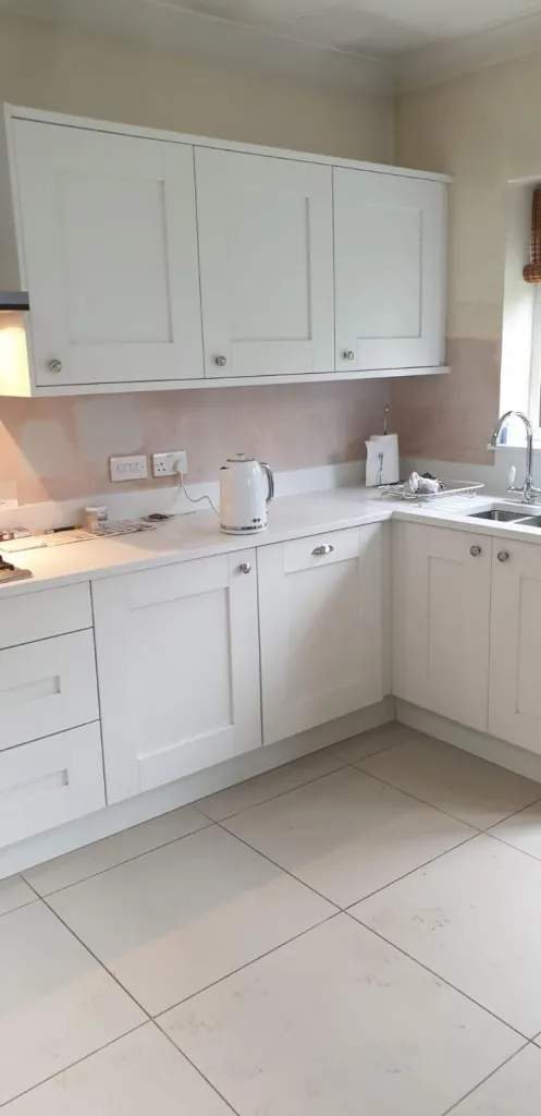 Classic cream painted Shaker kitchen in a corner layout with tiled floor