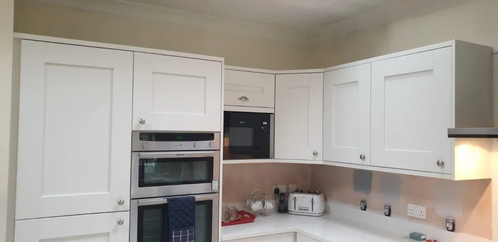 Cream Shaker kitchen with built-in double ovens and cornice detailing