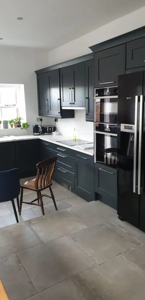 Dark painted Shaker kitchen with tall cabinetry and built-in ovens