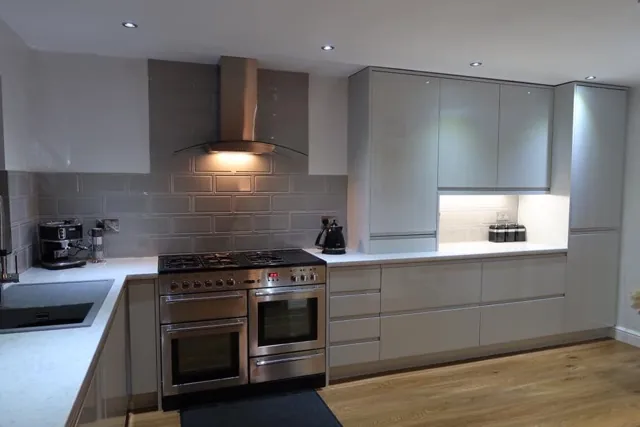 Grey kitchen with range cooker, stainless extractor and metro tiled splashback