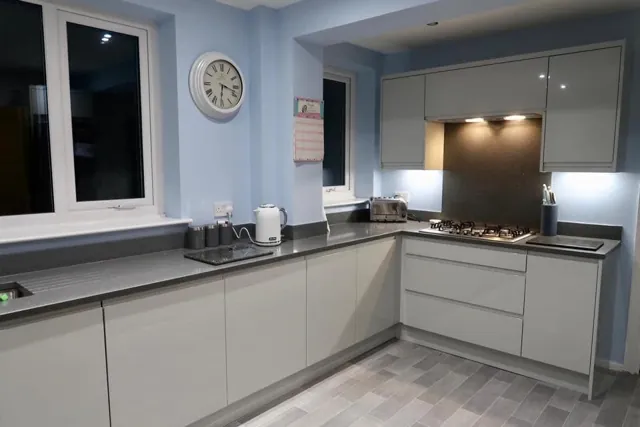 Light grey kitchen with dark worktops in an L-shaped layout