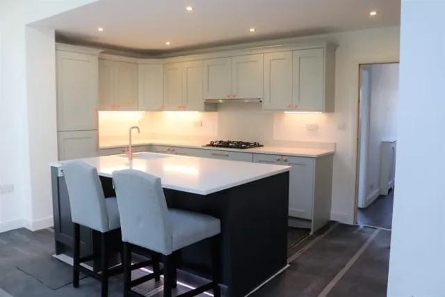 Cream painted Shaker kitchen with island and upholstered breakfast stools