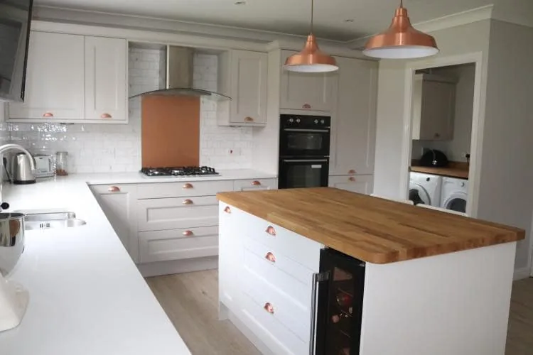 Painted Shaker kitchen with island, timber worktop and copper pendant lights