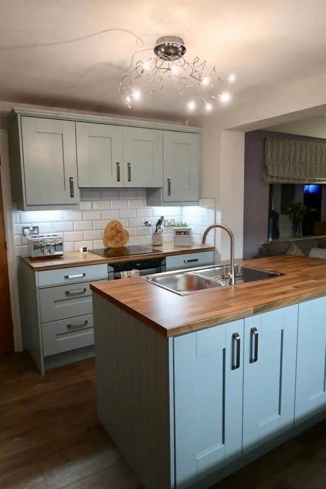 Pale blue Shaker island with solid timber worktop and inset sink