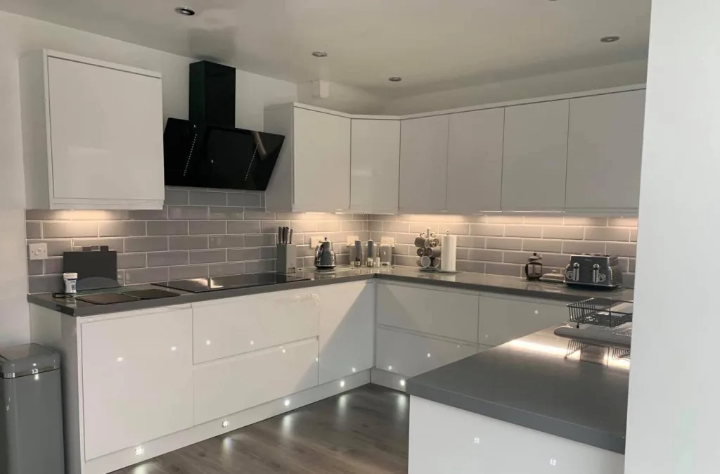 White handleless kitchen with grey worktops and angled extractor